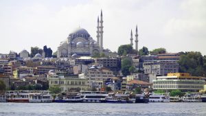 Istanbul skyline featuring the Suleymaniye Mosque, boats along the Bosphorus, and vibrant city architecture.