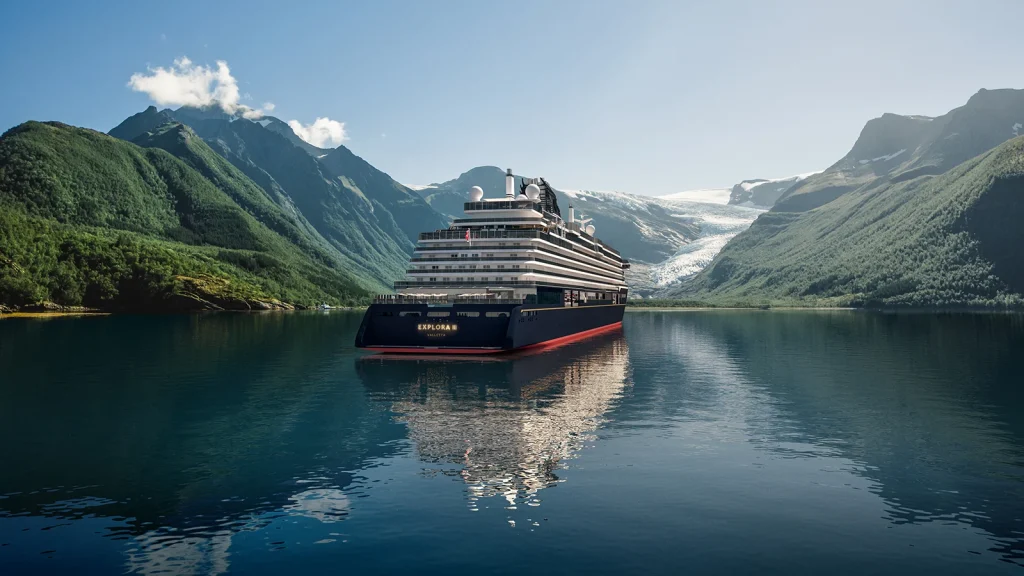 Explora III cruise ship anchored in tranquil waters surrounded by majestic mountains and a glacier, showcasing unique travel experiences in off-the-beaten-path destinations.
